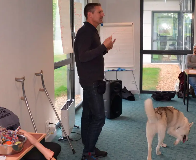 formateur en éducation canine avec un chien devant des élèves en formation
